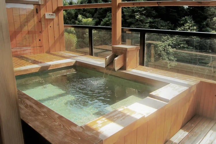 Open-air bath with a cypress tub in a guest room