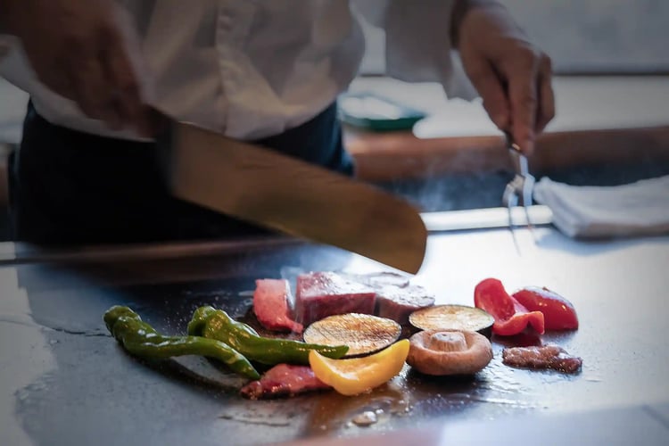 The scene of Wagyu steak being cooked on a teppan grill