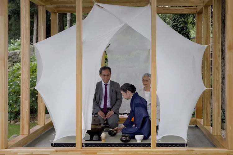 The host and guest respectfully partake in green tea, demonstrating mutual reverence for one another