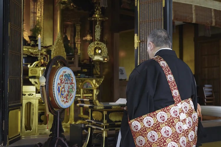 A Buddhist monk chanting sutras in a temple_s main hall