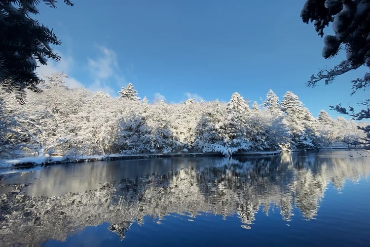 Snow-covered Kumoba Pond Winter_s deep blue sky and water surface