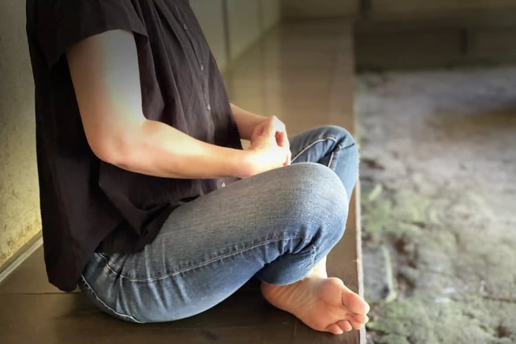 The lower body of a woman practicing Zazen on an engawa veranda