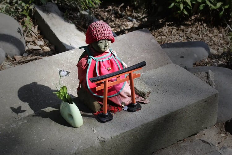 The red bibs and hoods placed on Jizo statues are believed to have originated from local people seeing Jizo Bodhisattva as a sacred Buddha that mirrors the image of a child