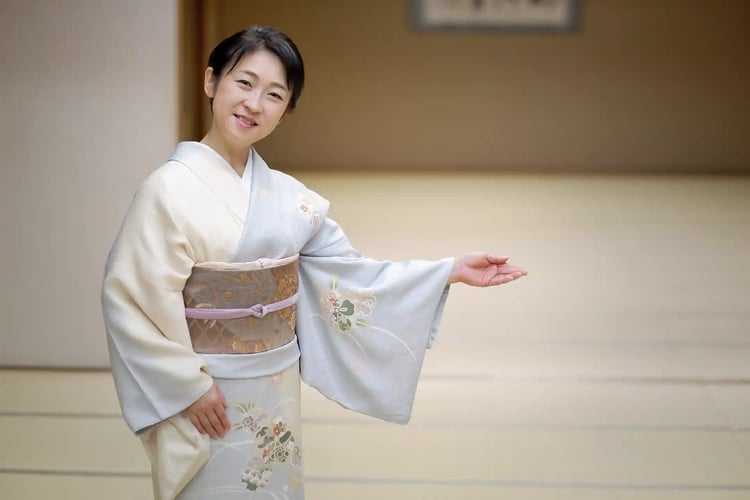 A middle-aged woman in a kimono welcomes you