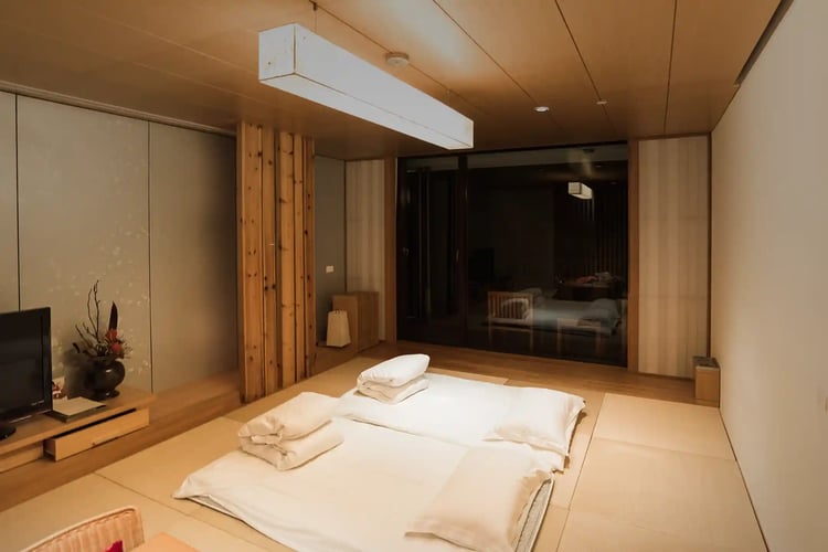 a Japanese-style bedroom with a futon on a tatami mat floor