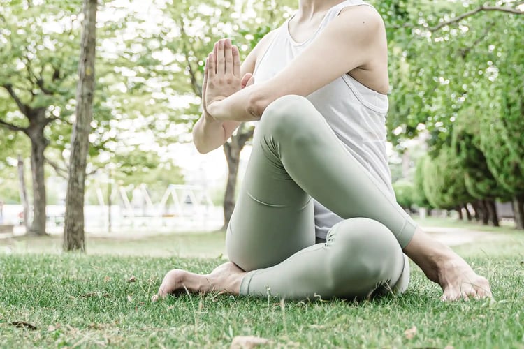 A woman doing yoga in the park
