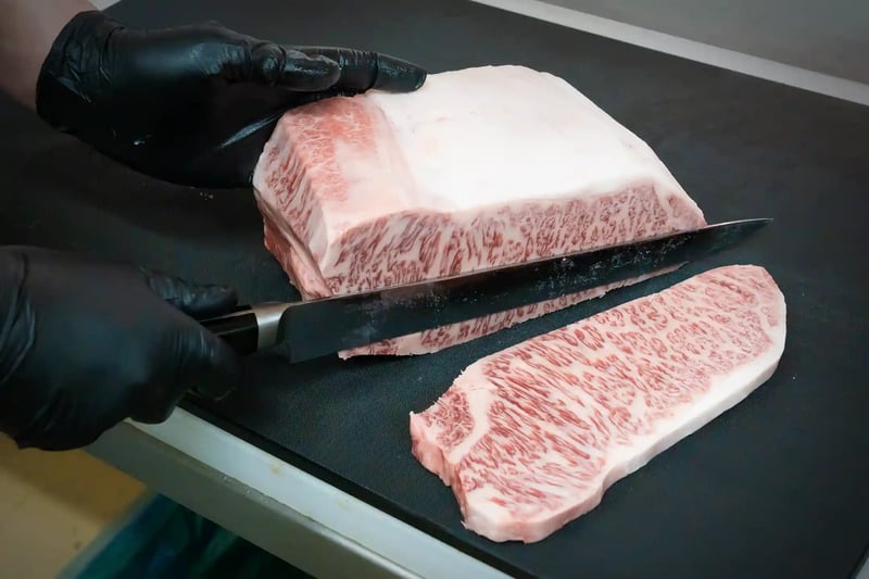 A butcher cutting a wagyu steak by hand