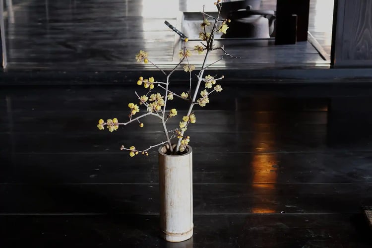 A beautiful ikebana with yellow flowers in a traditional Japanese house