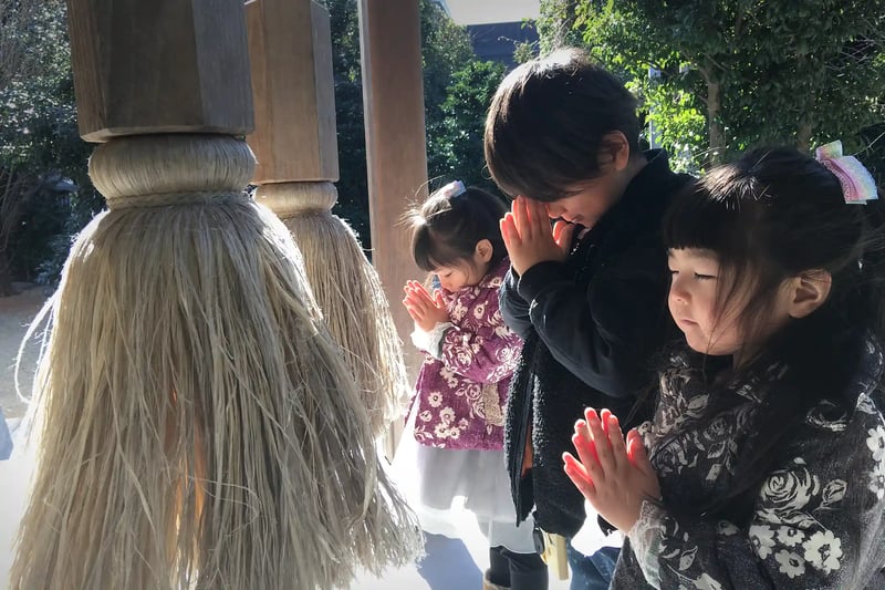 Children praying at a shrine (with their siblings)