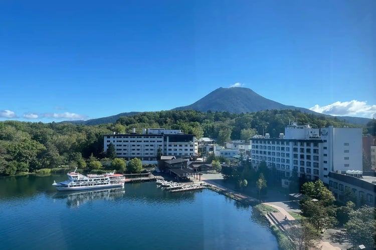 Mountains, a blue sky, a boat dock, and a hotel