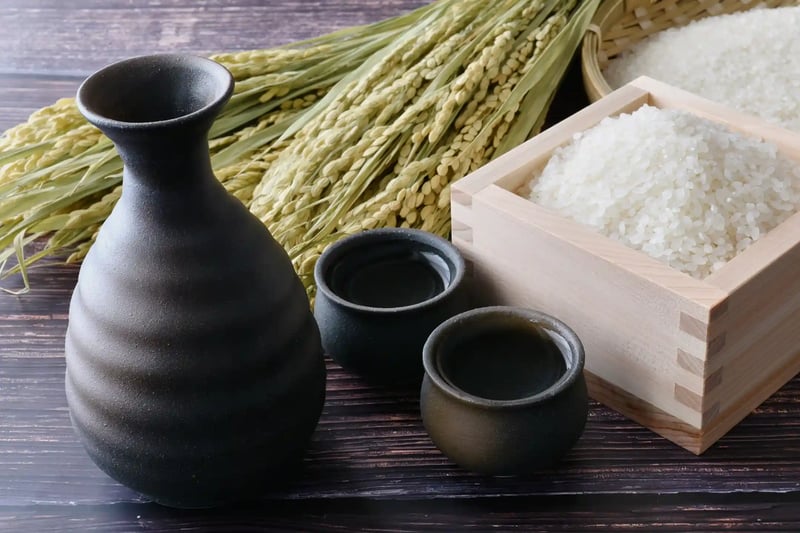 Sake, a tokkuri (sake carafe), an ochoko (sake cup), and rice stalks