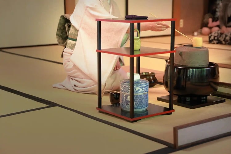 A tea practitioner (or tea master) whisking (or preparing) tea