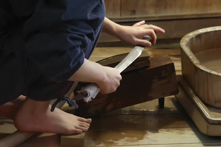 The hands of a master polisher sharpening a Japanese sword
