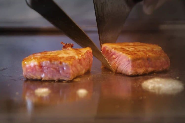 Cutting Kuroge Wagyu beef on the teppanyaki grill