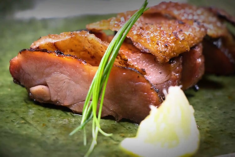 Charcoal-grilled Jidori chicken with miso (or Miso-grilled Jidori chicken), served at an Izakaya. The smoky aroma from the charcoal enhances the meat, often garnished with baby green onions and a squeeze of lemon