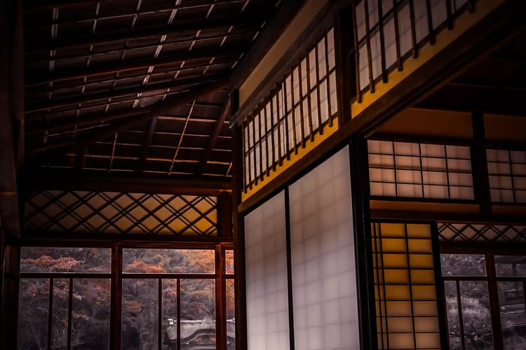 A plum bonsai by the window of a Japanese house