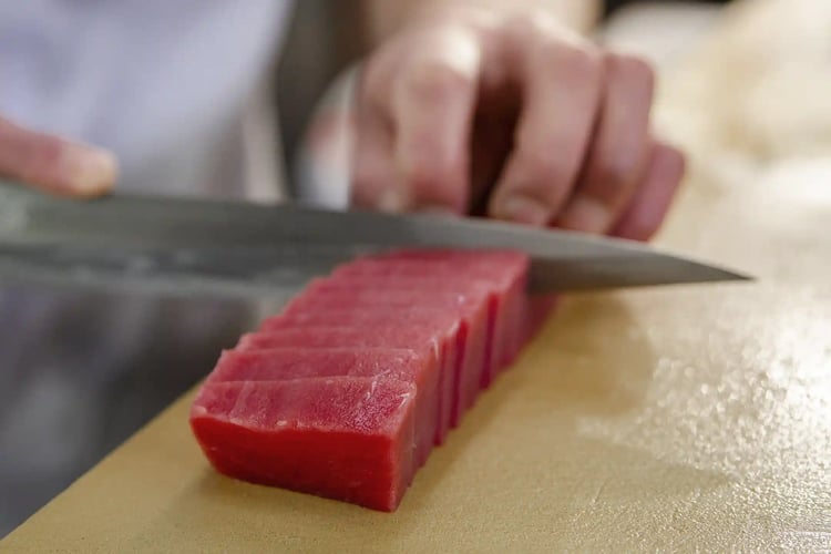 A Chef Slicing Tuna (Maguro) for Sashimi