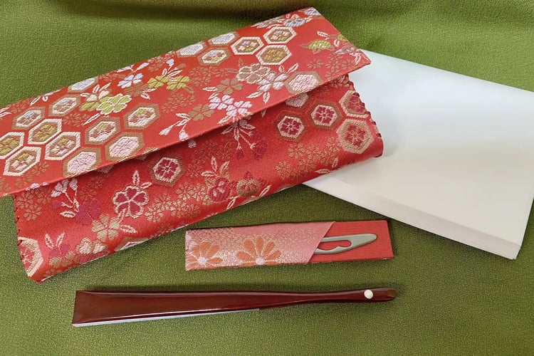 A Traditional Japanese Tea Ceremony Set Featuring Kaishi Paper, a Folding Fan, and a Kashikiri Knife
