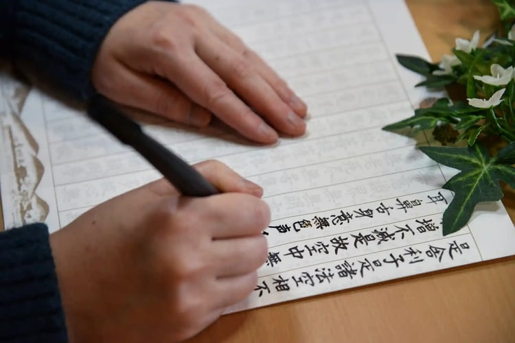 A woman_s hands performing calligraphy and sutra copying
