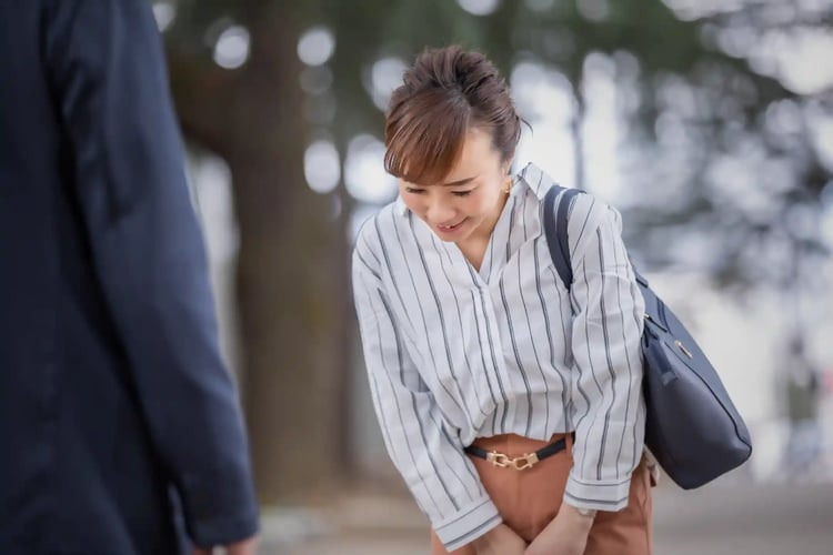 A business casual office worker giving a slight bow