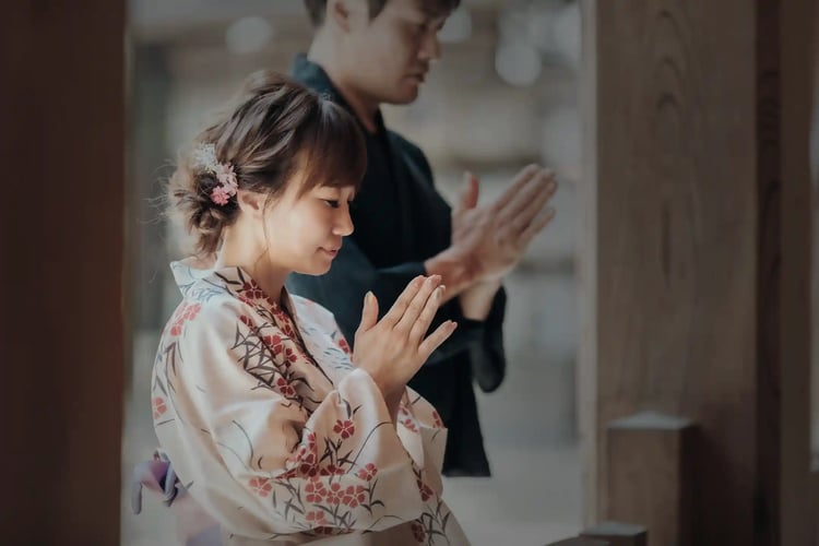 To pray with hands clasped together at a Shinto shrine