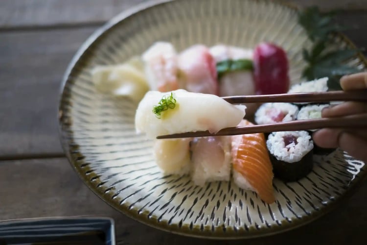 Grasp sushi with chopsticks