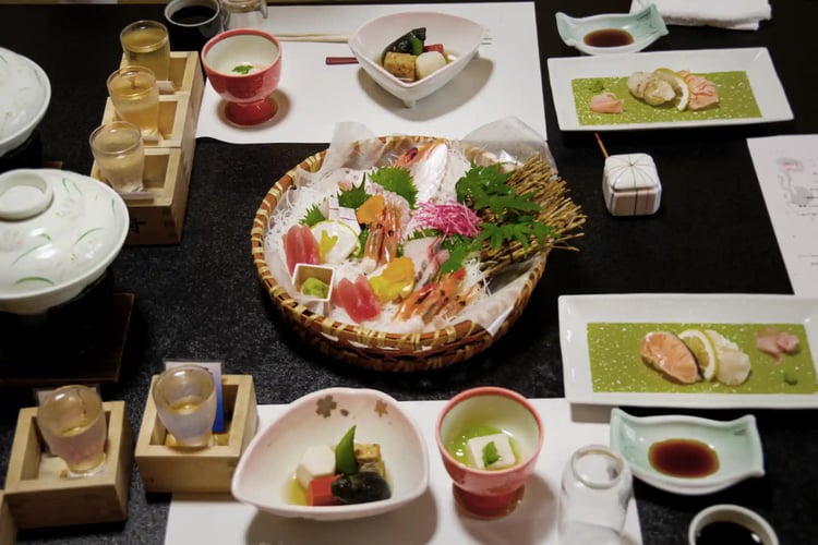 A dinner gathering with local sake and fresh local fish at a traditional Japanese inn (ryokan)