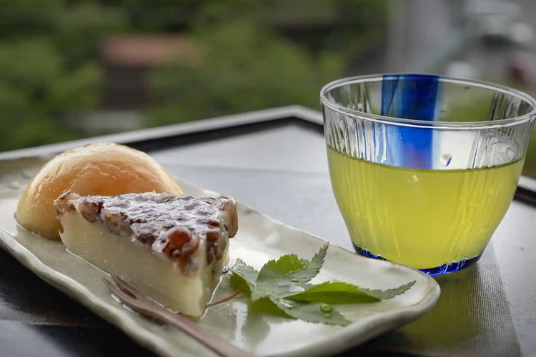 A cup of tea with peaches and wagashi