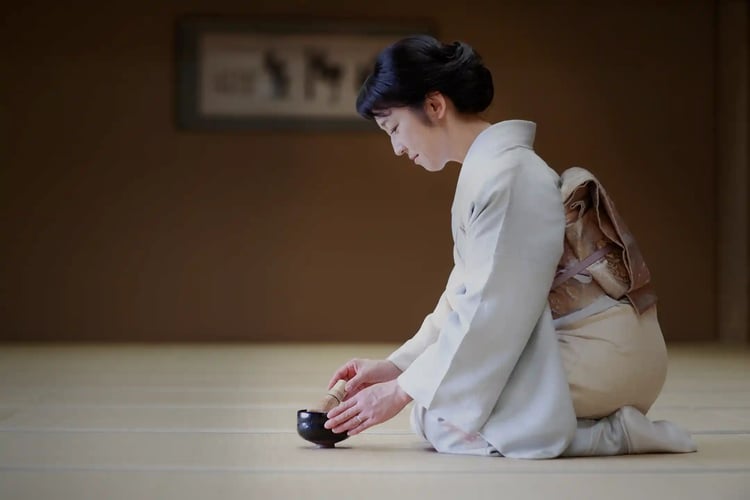 A middle-aged woman in a kimono sitting on tatami