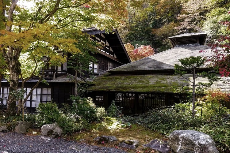 The historic wooden architecture of Hoshi Onsen looks stunning against the backdrop of autumn leaves