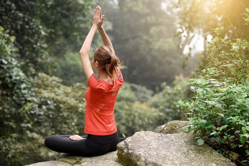 A woman doing yoga on a rocky mountain