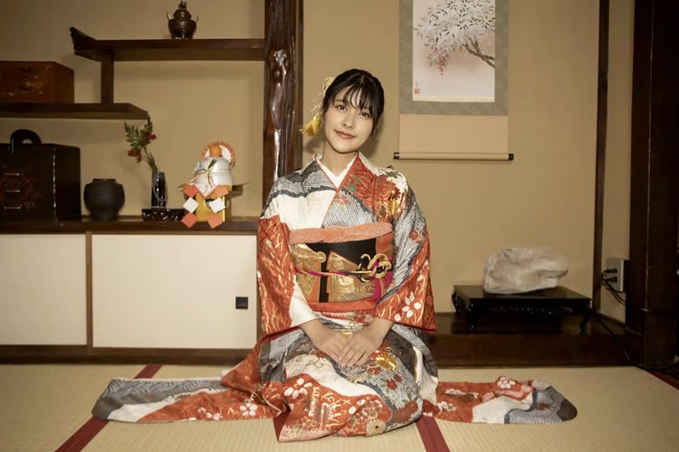 A woman in a furisode sitting in a Japanese-style room