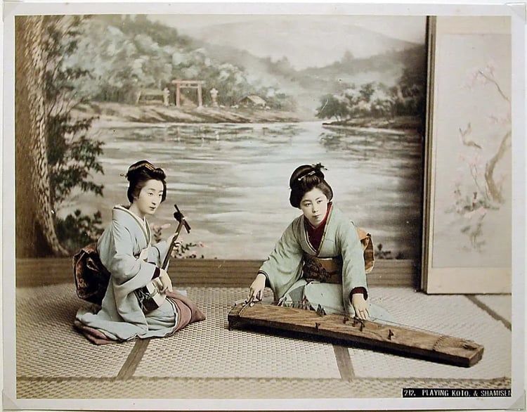 Hand-colored Meiji-era photograph by Kusakabe Kimbei showing one musician seated at a koto beside a shamisen player