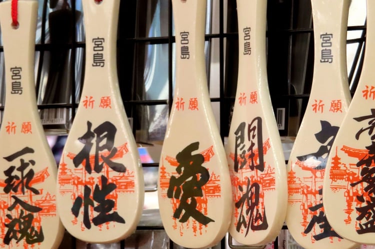 Painted Miyajima shamoji rice paddles hanging in a shop