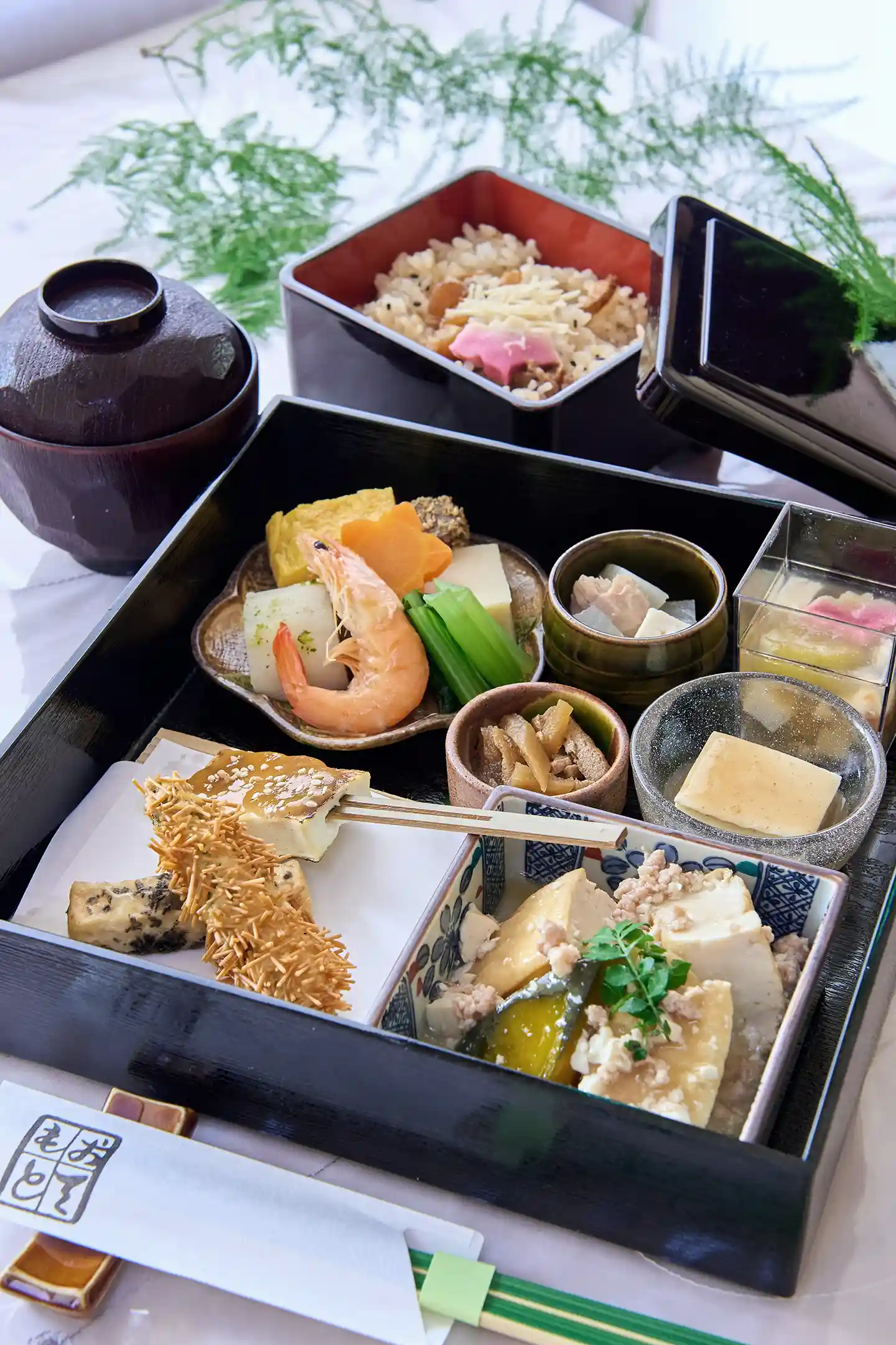A layered box (Oju) containing seasonal cuisine