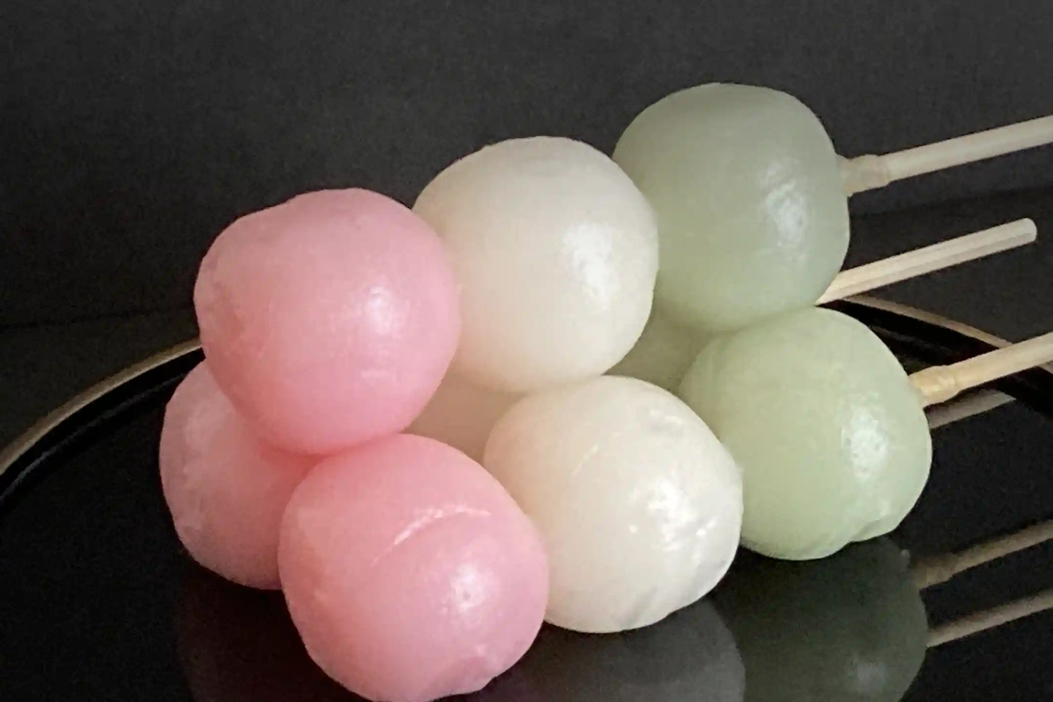 Pink, white and green hanami dango on a skewer
