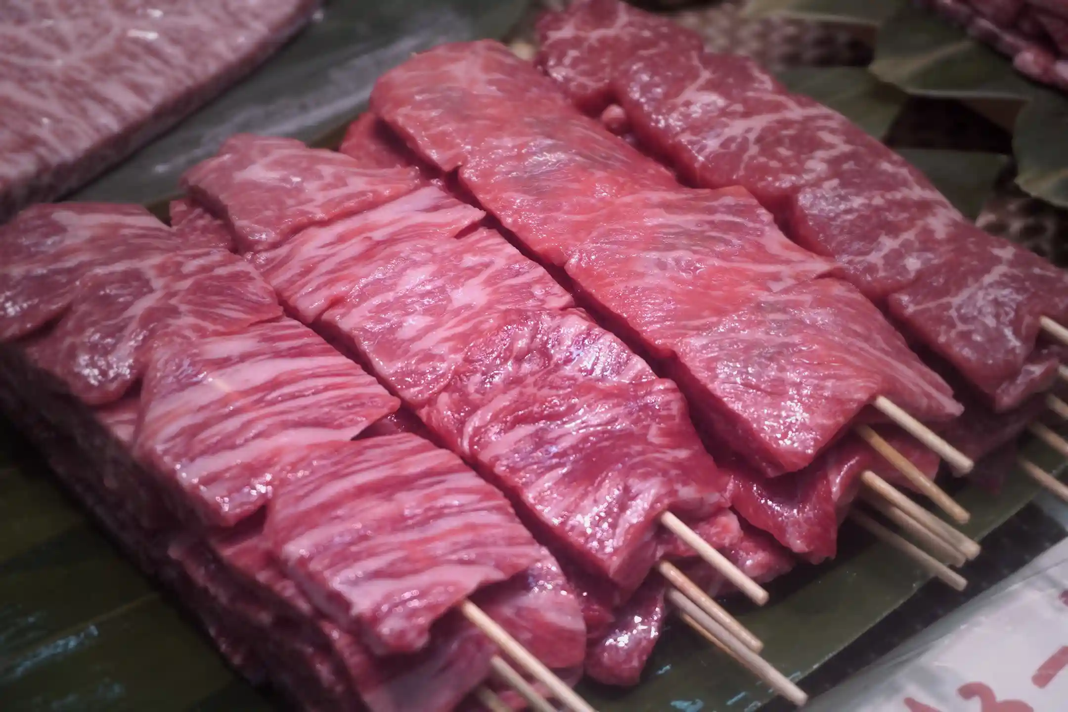 Wagyu beef skewers grilling at a Kuromon Ichiba Market stall
