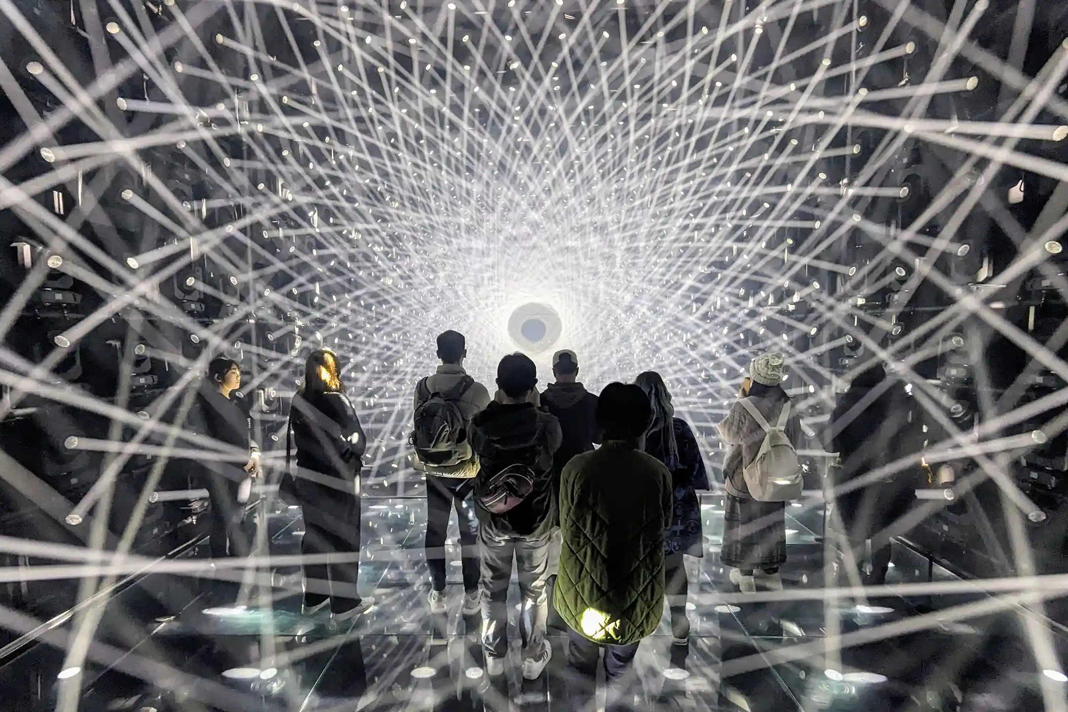 A visitor inside teamLab Borderless at Azabudai Hills, surrounded by projected light