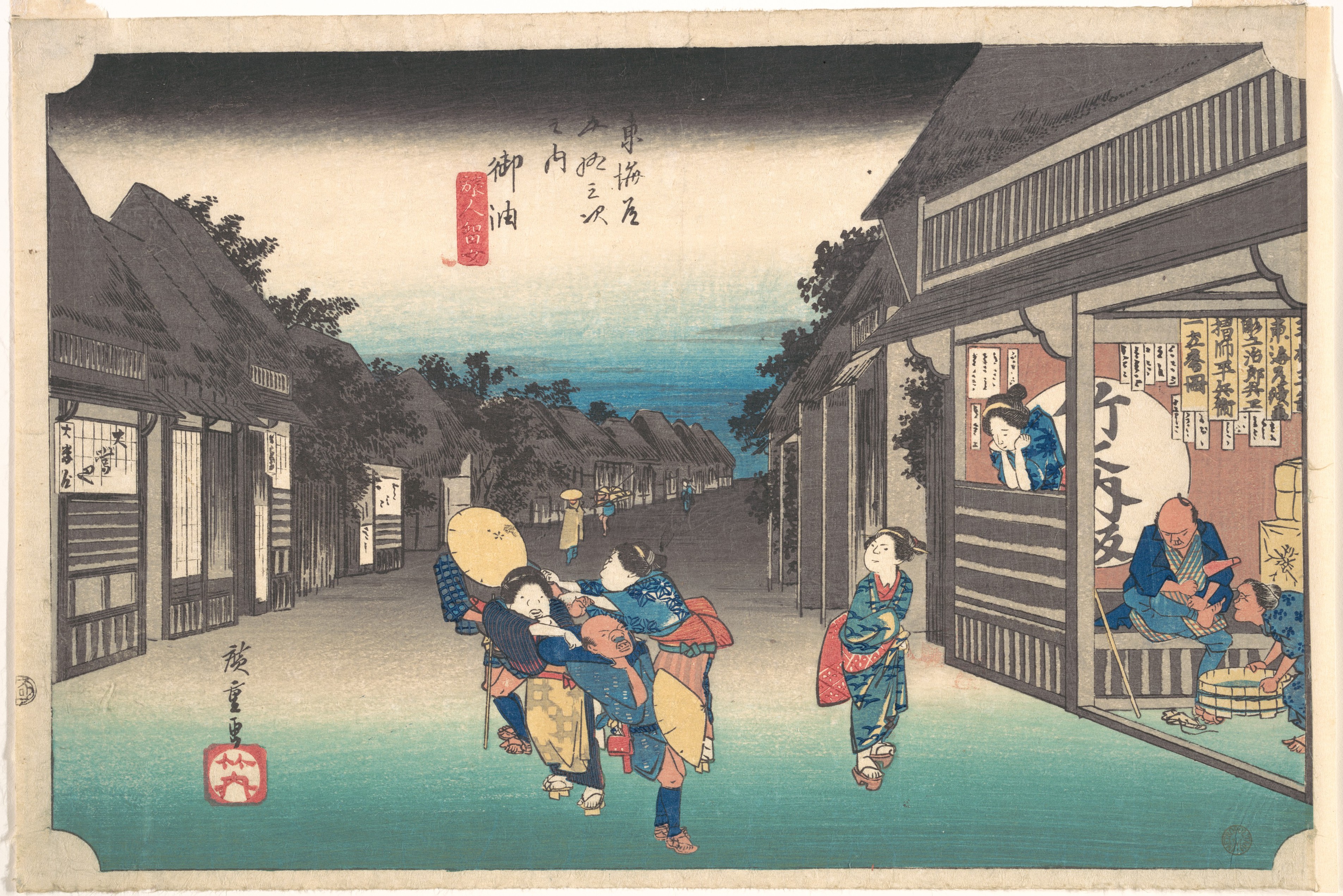 A Hiroshige print of the post town of Goyu at dusk, with women taking hold of passing travellers outside the inns while a guest is attended to in a lit room