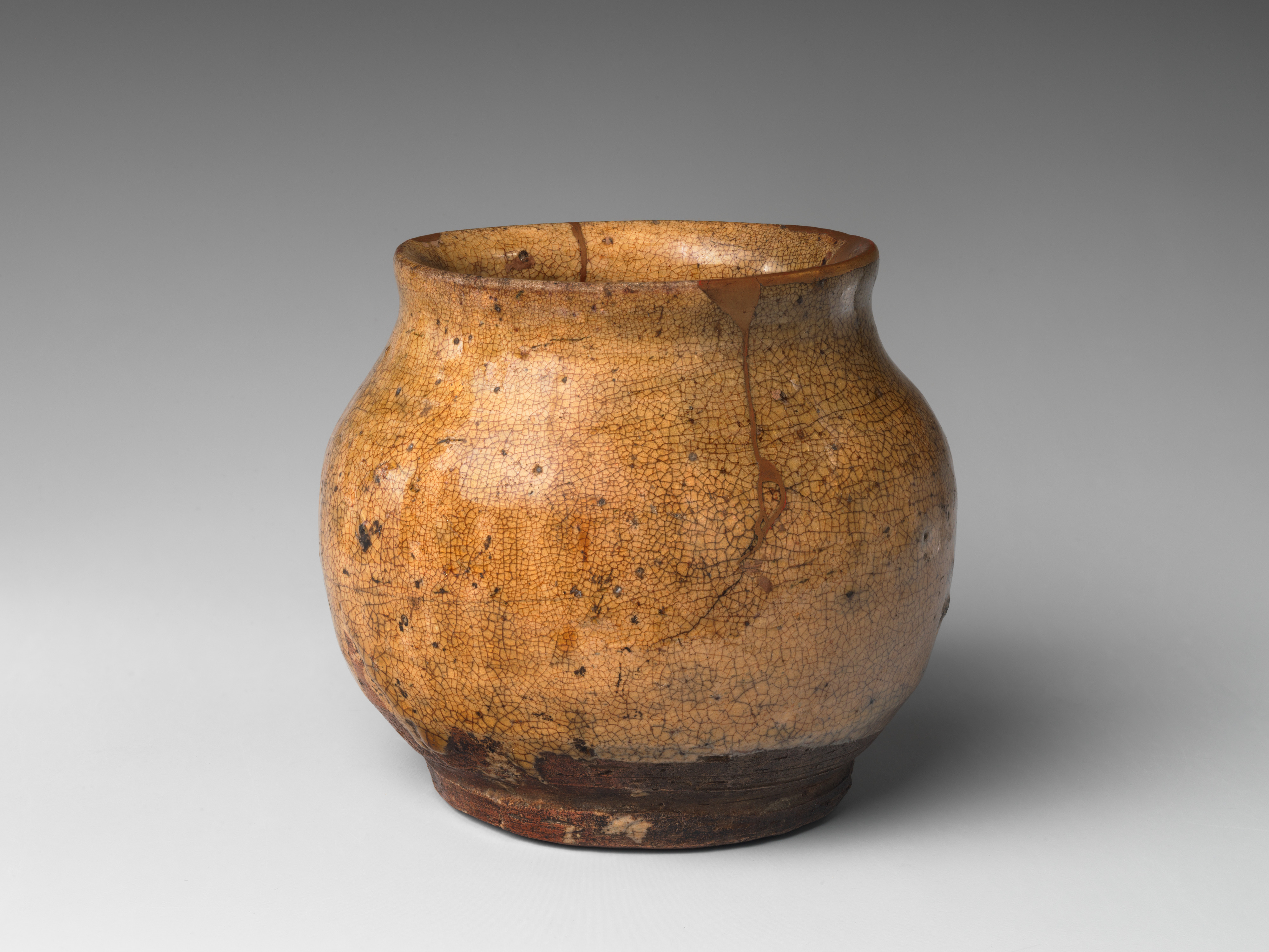 A late sixteenth- or early seventeenth-century Karatsu jar in the Metropolitan Museum of Art, catalogued as stoneware with ash glaze and gold lacquer repairs