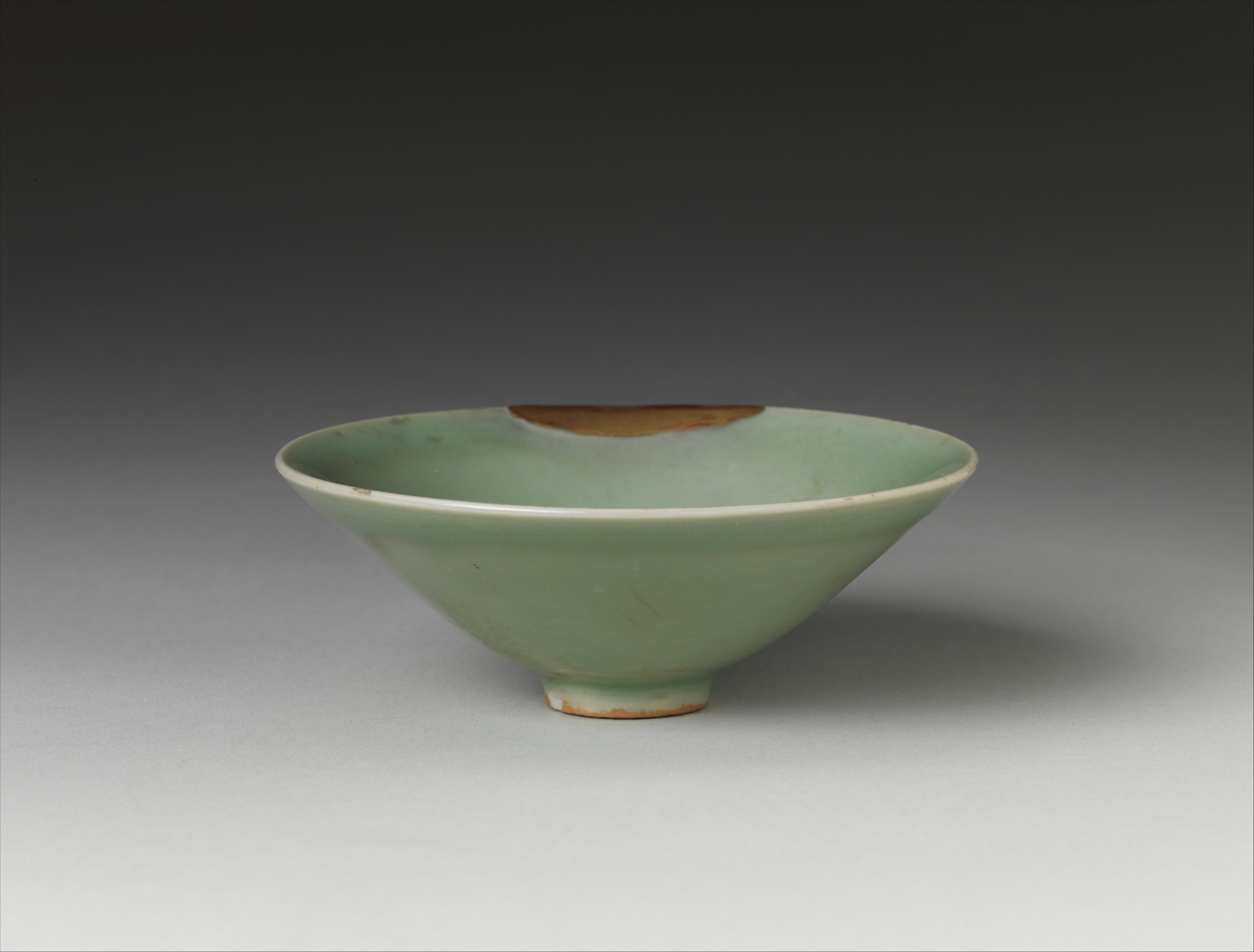 A thirteenth-century Longquan celadon tea bowl in the Metropolitan Museum of Art, catalogued with gold lacquer repairs