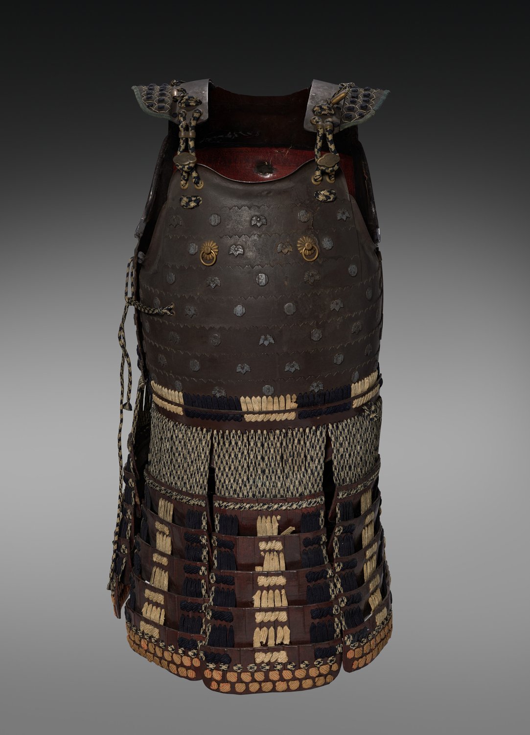 A cuirass and fauld of Japanese armor from the 1600s, with rows of small plates bound together by laced cords below the chest plate