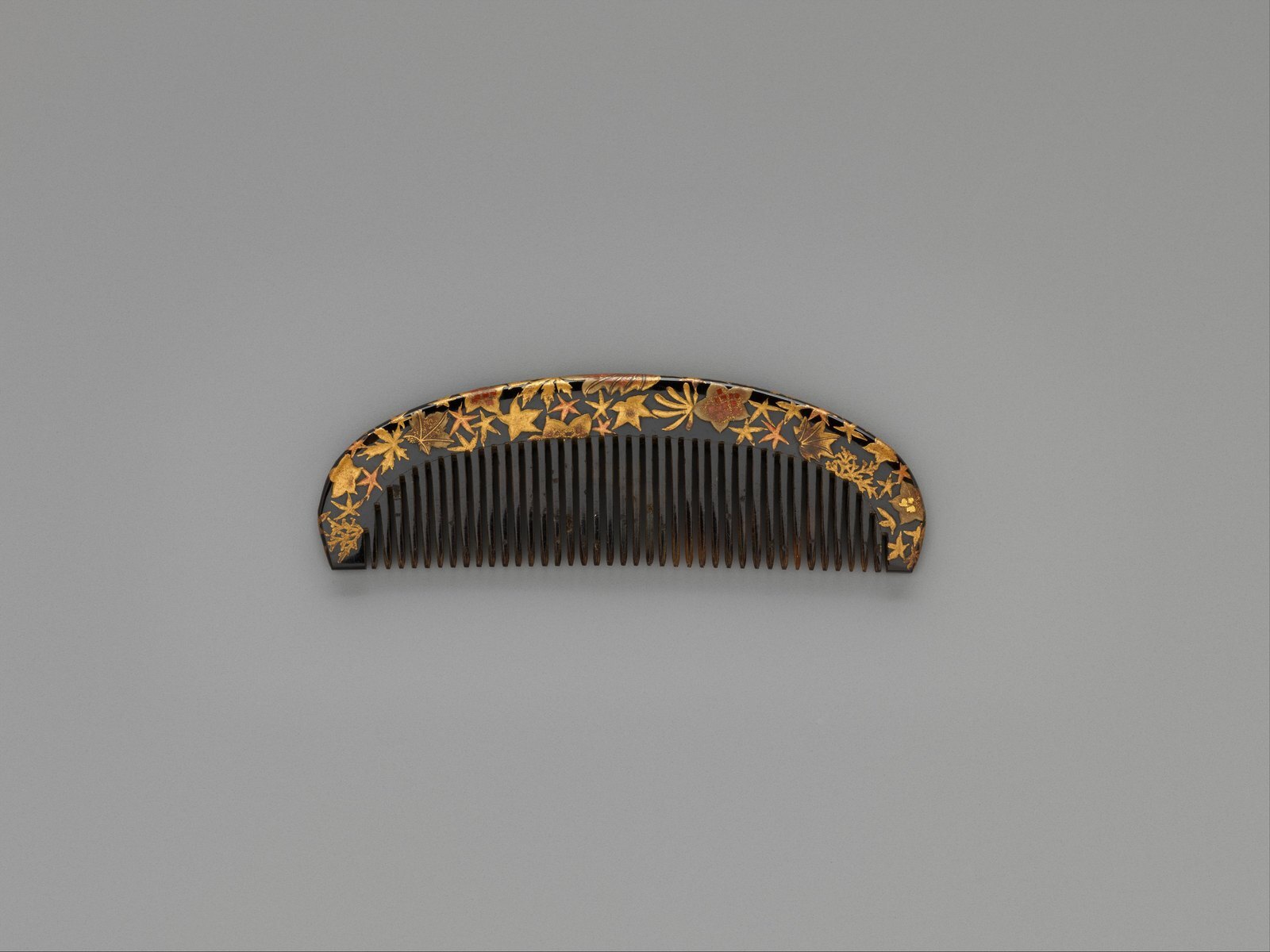 A lacquer comb decorated with maple leaves, the kind of hair ornament held in museum collections