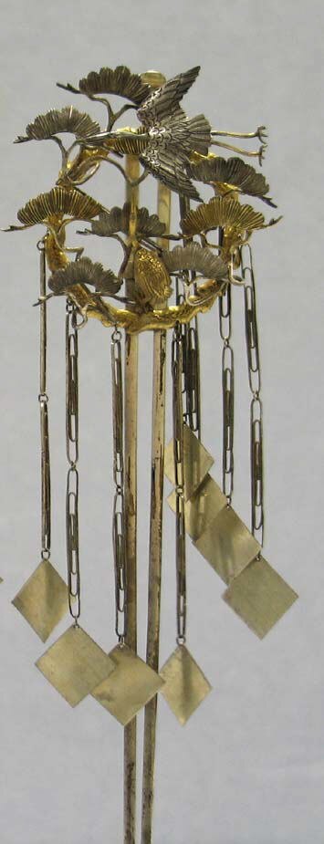 A slender silver hair ornament with long hanging elements
