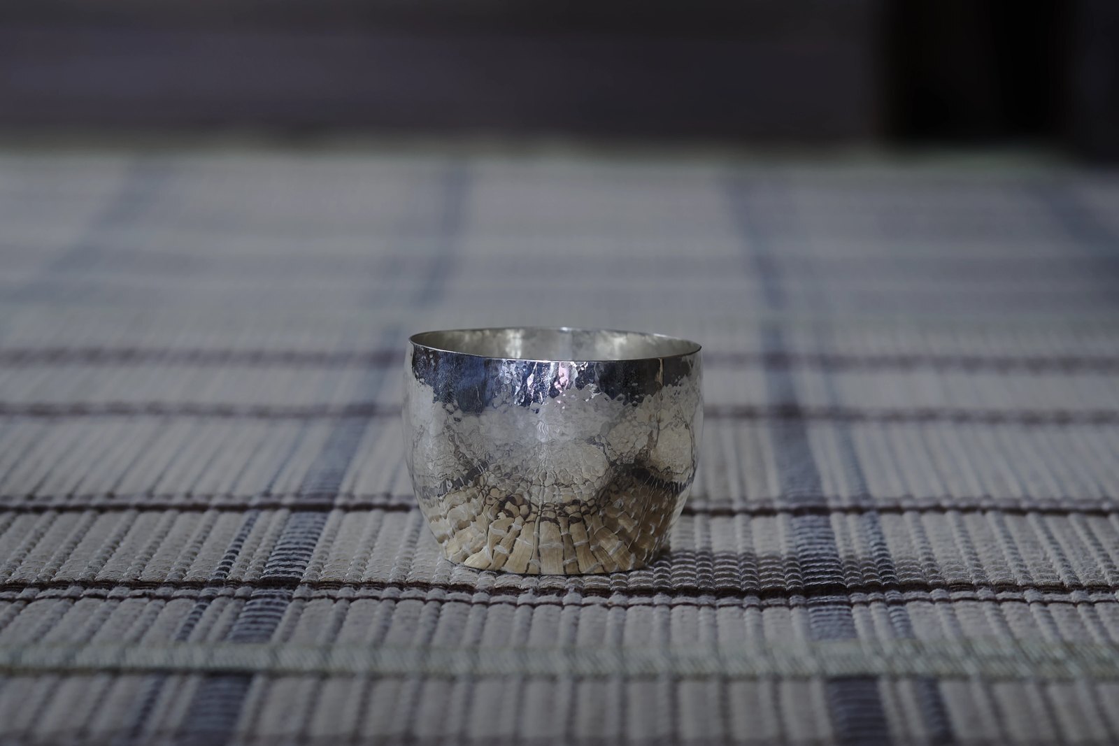 A small silver cup whose faceted surface still carries the marks left by the hammer