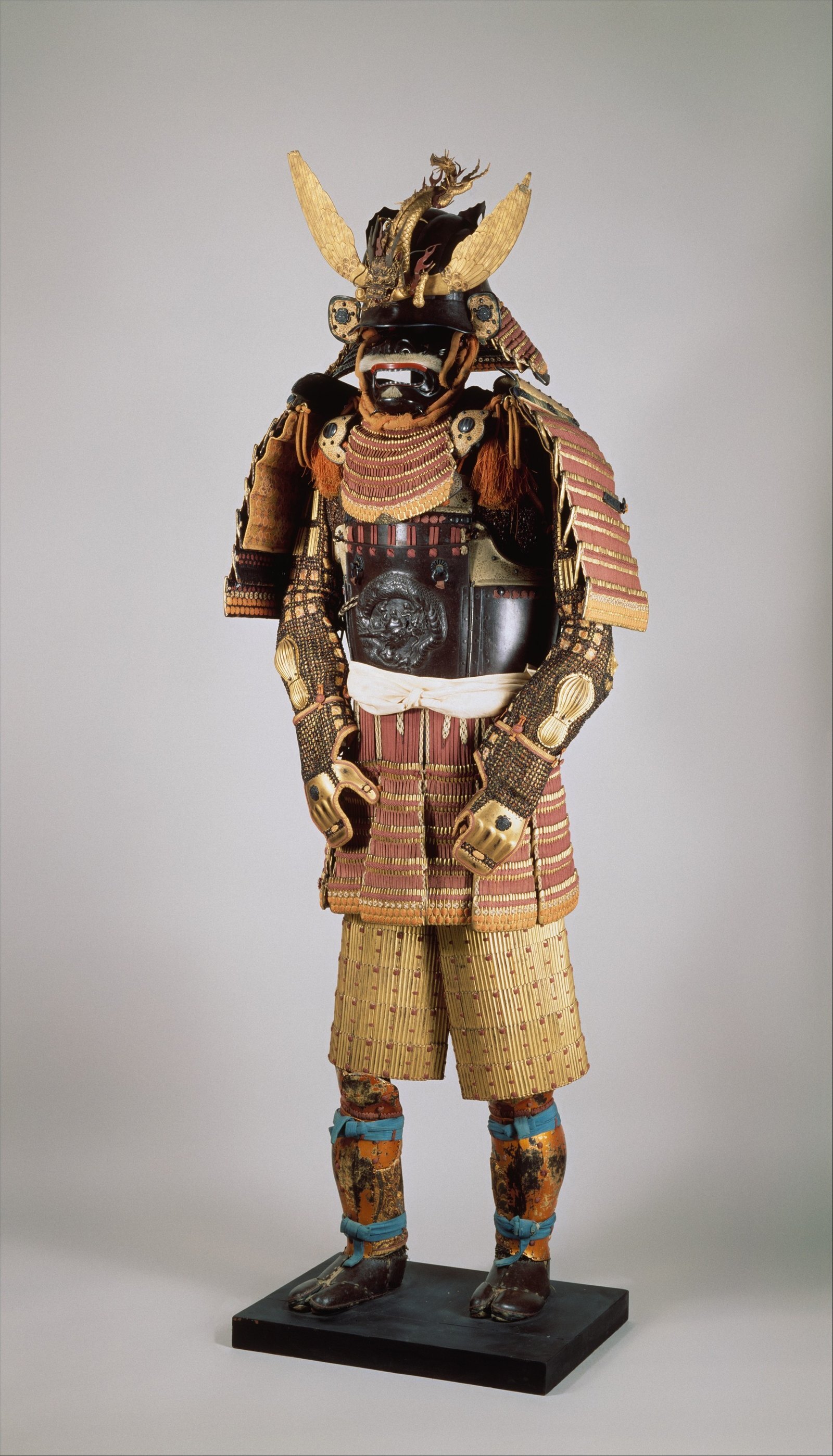A full suit of Japanese armour on a stand, the laced plates and horned helmet that kendo armour descends from